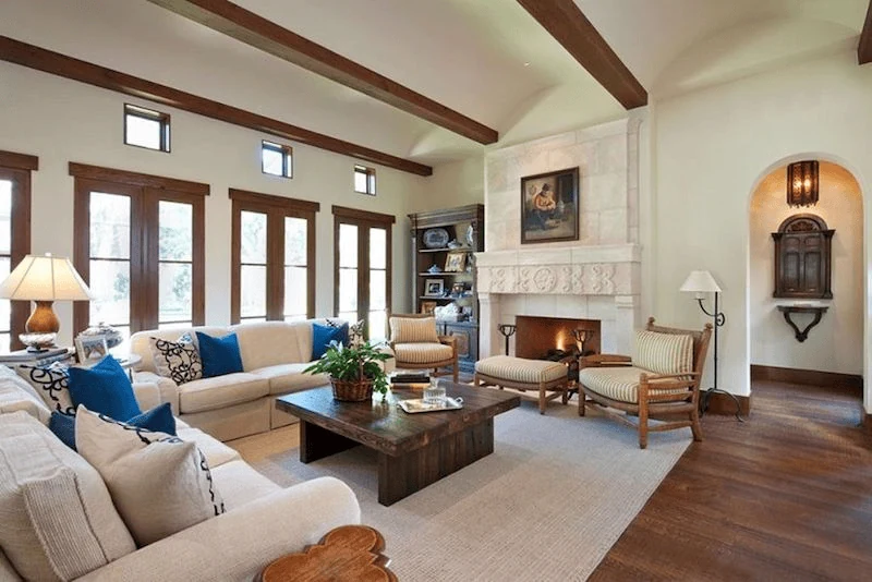 Mediterranean interior design style living room with timber beams and stone fireplace